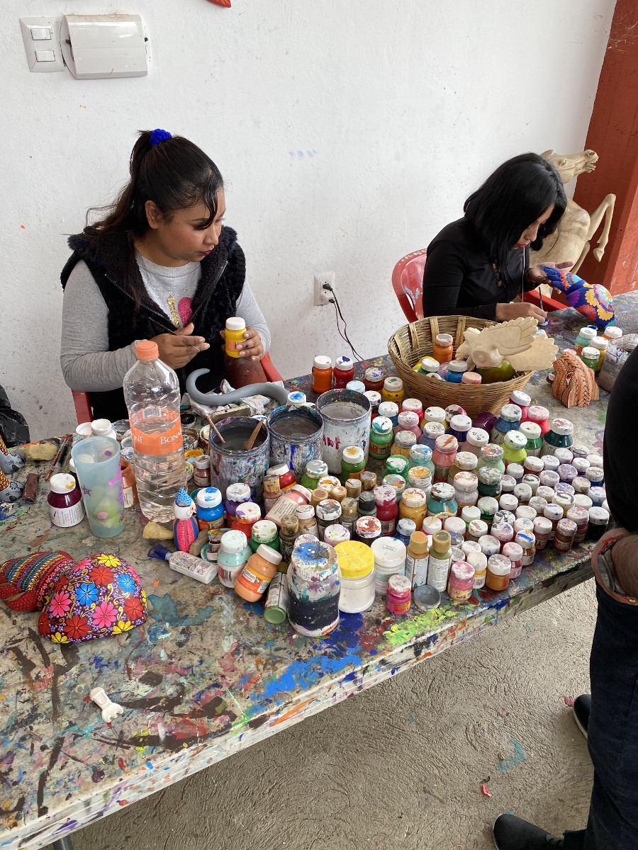 Craftswomen painting alebrijes