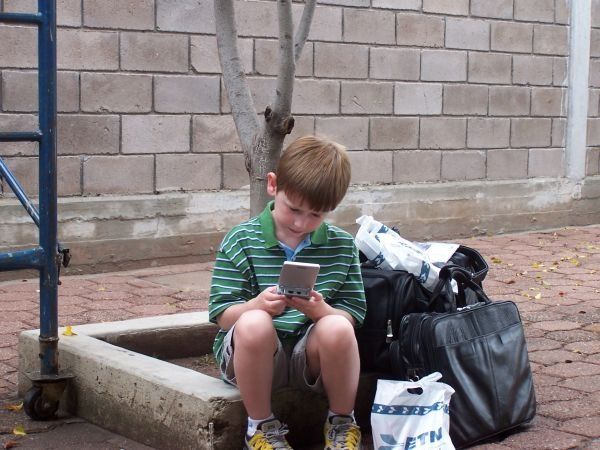 Matthew Waits for our Bus — With Gameboy of course